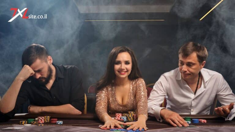 שלושה שחקנים יושבים סביב שולחן poker 7xl עם קלפים וערימות ז׳יטונים צבעוניים באווירת קזינו מעושנת.